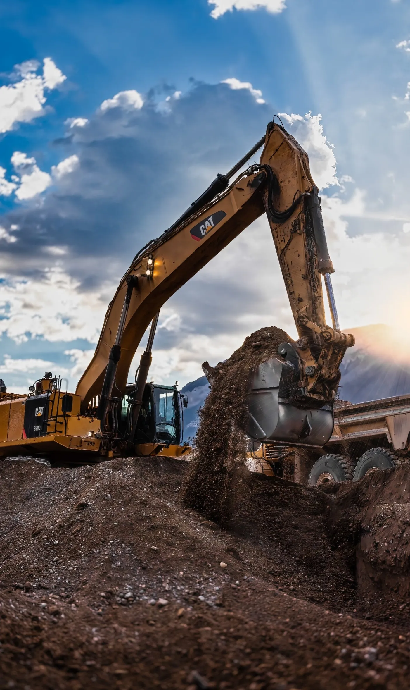 Mackay excavator loading a rock truck against a sunburst sky at Kootenay West Mine